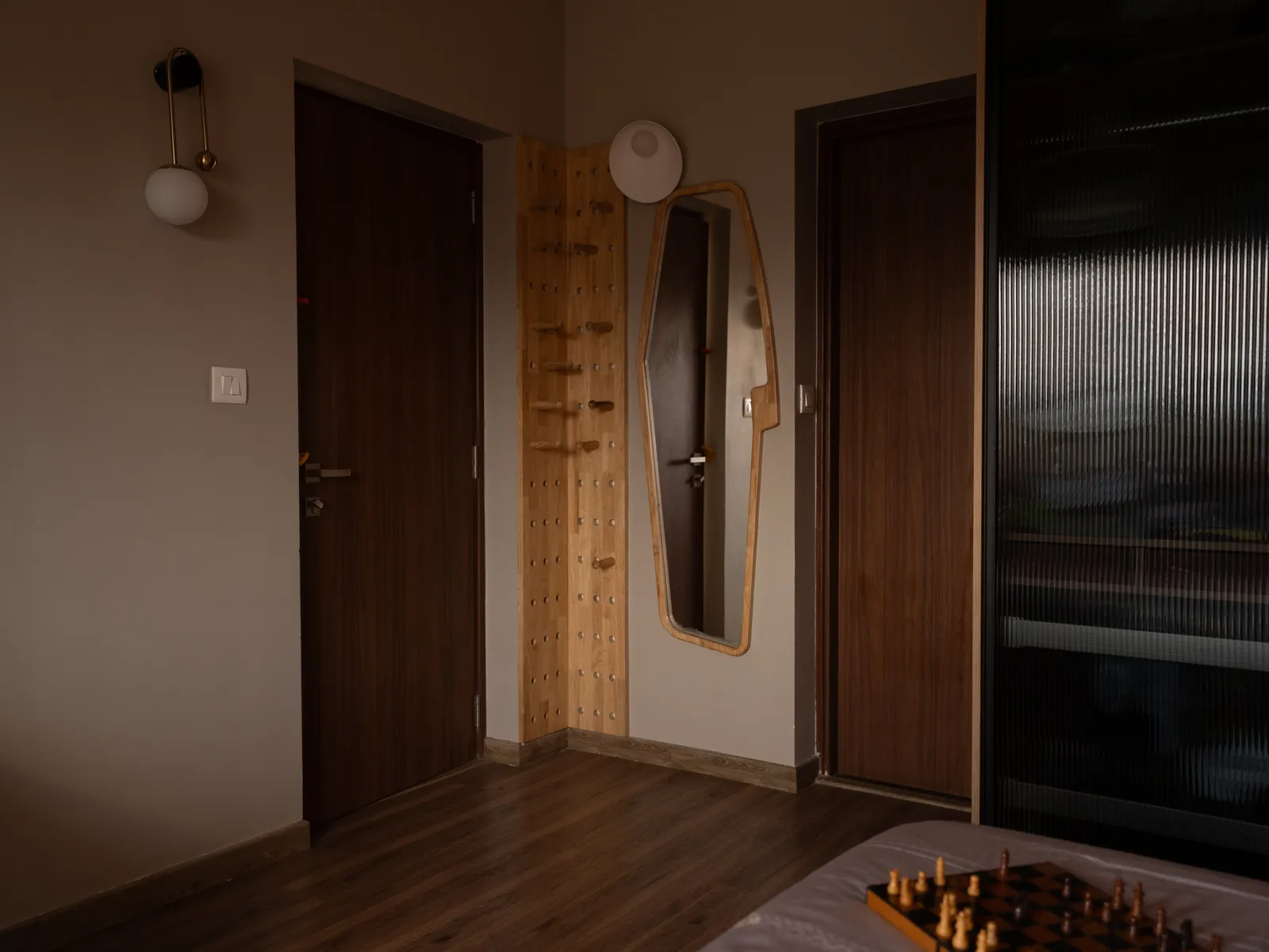 Bedroom with walnut doors and full-length mirror — Amlan's Residence